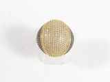 gros plan d'une bague en or et en argent sur une surface blanche