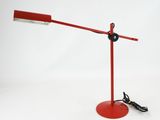 une image représentant une lampe de bureau rouge sur fond blanc