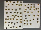 two pieces of paper with gold and silver buttons on them