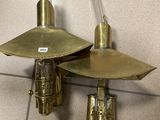 pair of brass wall sconces on a tiled wall in a bathroom