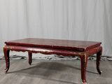 une photo d'une table basse rouge posée sur un parquet