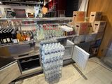 many bottles of water sitting on the counter in the store