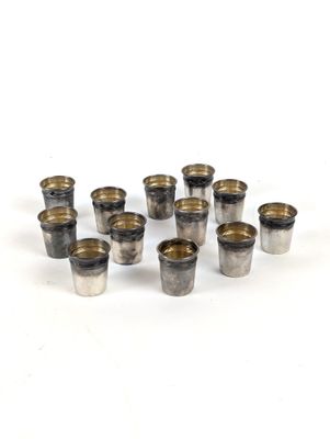 Plusieurs verres à shot sont disposés en cercle sur une surface blanche