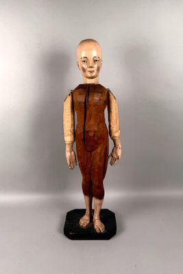 statue of a man with a bald head wearing a brown dress