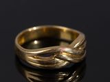 gros plan d'une bague en or sur une surface noire