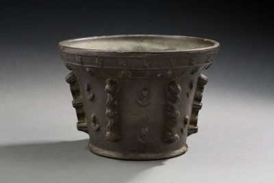 une grande tasse en métal ornée d'un motif