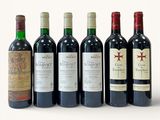 several bottles of wine are lined up in a row on a white surface