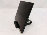 a black tablet computer sitting on a stand on a white surface