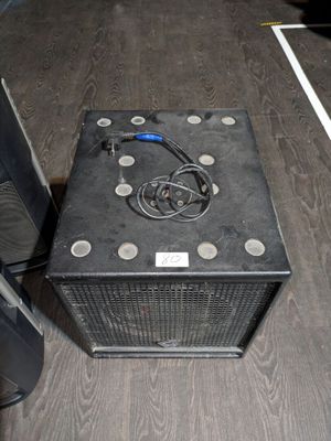 a black amp sitting on the floor next to a speaker