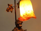 a lamp that has a statue on it with a flower on it