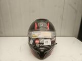 le casque, noir et rouge, est posé sur une table blanche