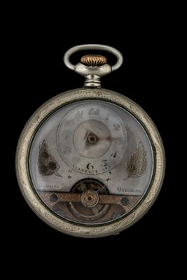 a close up of a pocket watch on a black background