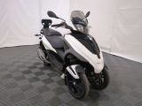 a white and black motorcycle parked on a black and white checkered floor