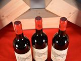 three bottles of wine sitting on a red cloth