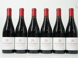 six bouteilles de vin rouge sont alignées sur une surface blanche