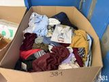 un carton rempli de vêtements sur le sol