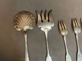 five spoons and a fork on a table