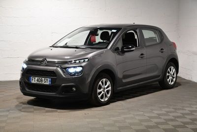 La Citroën grise est garée dans un garage au sol carrelé en damier.