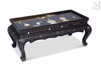 une table basse noire avec un plateau en verre sur fond blanc