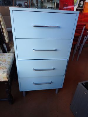 a blue chest of drawers in the corner of a room