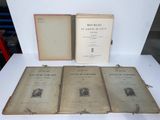 three old books sitting on top of a white table next to each other