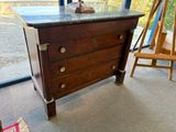 une commode en bois avec un plateau en marbre dans une chambre