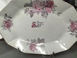 a white plate with pink roses on it on a table