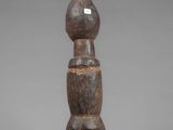 a wooden sculpture of a person standing on a base