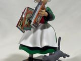 figurine of a woman reading a book with a cat nearby