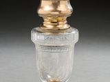 an old fashioned glass jar with a gold lid on a table