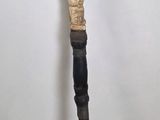 a wooden stick with a carved handle on a wooden table