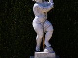 a statue of a boy holding a flower in his hand