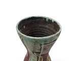 a small vase that is sitting on a white surface