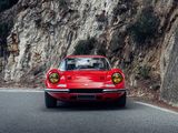 a red sports car driving down a mountain road