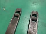two pieces of metal sitting on a green surface