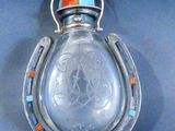 an image of a glass bottle with a horse shoe on it
