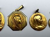three gold medals of the virgin mary and jesus on a white background