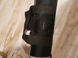 a black bag with a strap on it sitting on a wooden floor