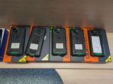 five different cell phones are sitting in a row on a table