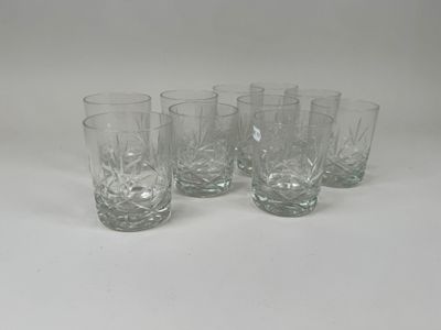 quatre verres à pied en verre transparent posés sur une table blanche