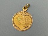 un gros plan d'un pendentif en forme de cœur en or orné d'une fleur