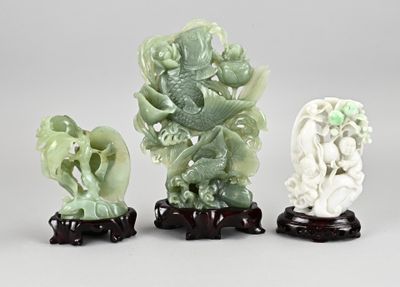trois figurines vertes et blanches représentant un dragon et un dragon sur un socle