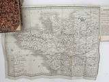 an old map of france with a book on top of it