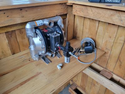 une petite pompe posée sur une table en bois dans une pièce