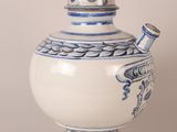 a blue and white vase with a lid on a table
