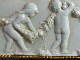 a picture of a white and gold plate with a boy and a girl