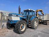a tractor that is parked next to a dump truck