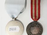 two medals and a medal on a white surface