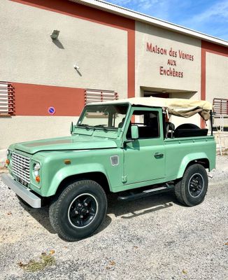 an image of a green land rover parked in front of a building