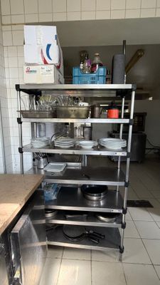 a kitchen with a stove, dish rack, sink and dishwasher in it
